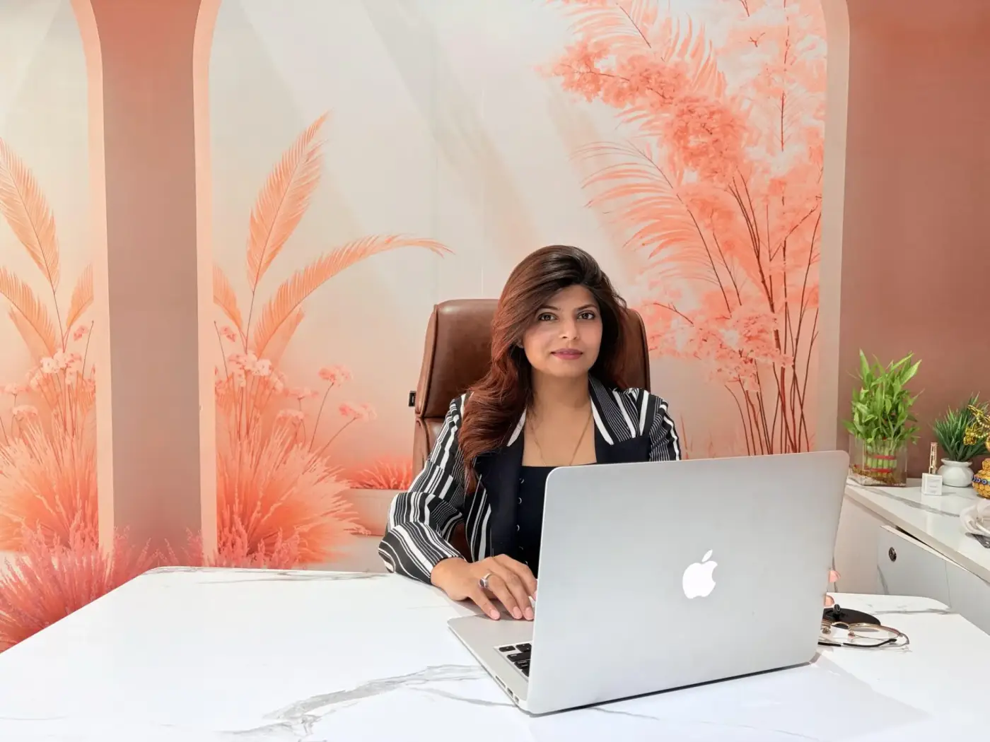 Director of Luxtique Academy in a reflective seated portrait at her desk